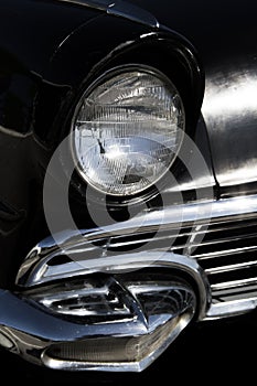 Classic old sixties black car front headlight and grill