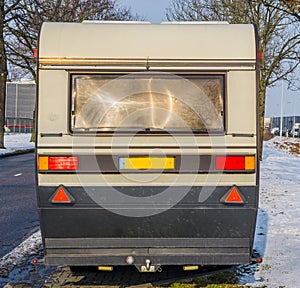 Classic old vintage caravan from the back, mobile trailer for traveling on the road