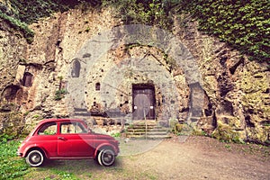 Classic old vintage red car. Archaeological area City of Sutri, Italy