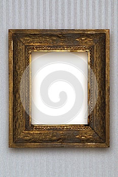 Classic old wooden picture frame carved by hand on gray wallpaper