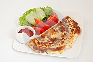 Classic omelet with cheese and tomatoes and cucumbers salad on a white plate
