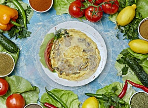 Classic omelet on a white plate with ingredients