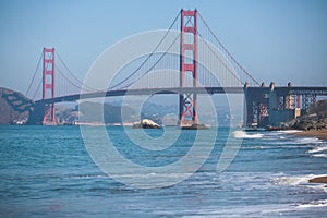 Classic panoramic view of famous Golden Gate Bridge seen from Baker Beach in beautiful summer sunny day with blue sky, San