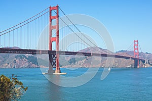 Classic panoramic view of famous Golden Gate Bridge seen from Baker Beach in beautiful summer sunny day with blue sky, San