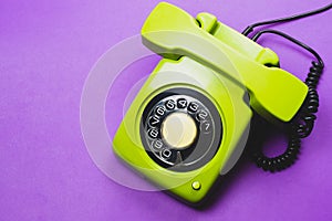 Classic phone with handset. vintage green telephone with phone receiver isolated on purple background. old communication