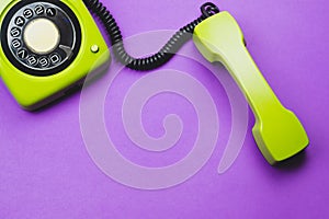 Classic phone with handset. vintage green telephone with phone receiver isolated on purple background. old communication