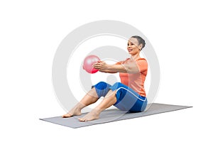 Classic pilates, roll up drill, starting position. Adult fit smiling woman does workout with pink small fit ball in