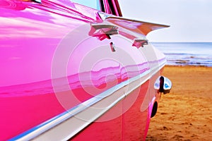 Classic pink Cadillac at beach