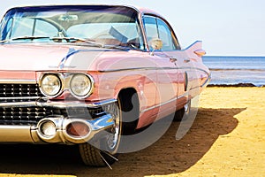 Classic pink Cadillac at beach