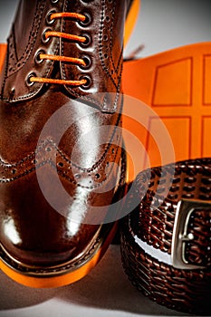 Classic polished men's brogues with orange sole and brown belt photo