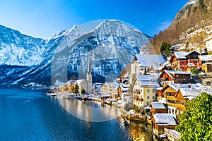 Classic postcard view of famous Hallstatt lakeside town in the Alps with traditional passenger ship on a beautiful cold sunny day