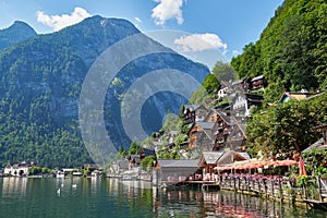 Classic postcard view of famous Hallstatt lakeside town reflecting in Hallstattersee lake in the Austrian Alps in scenic beautiful
