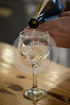 A classic pour of a glass of riesling on a wooden bar - WINE