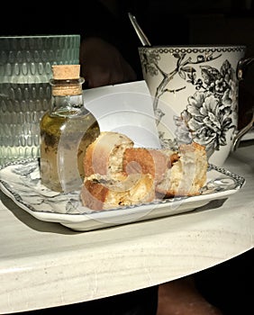 A classic presentation of bread and oil in a Parisian cafe