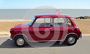 Classic Red Austin Mini motor car parked on Felixstowe seafront promenade.