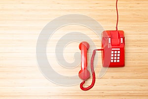 Classic red telephone on wooden desk