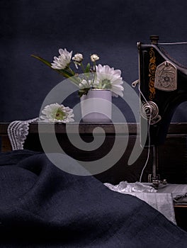 Classic retro style manual sewing machine ready for work, scissors, fabric and Chrysanthemum