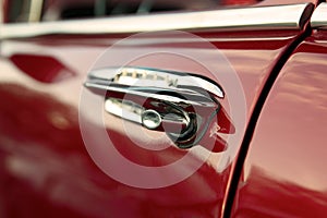 Classic retro vintage red car. Car door handle. The car is older than 1985