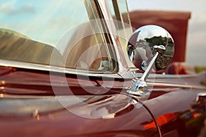 Classic retro vintage red car. Car mirror.