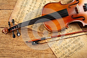 Classic retro violin music string instrumt with old music note sheet paper old oak wood wooden background. classical musical