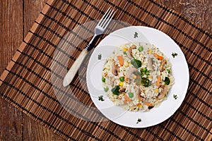 Classic Risotto with mushrooms and vegetables served on a white plate