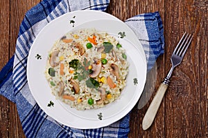 Classic Risotto with mushrooms and vegetables served on a white plate