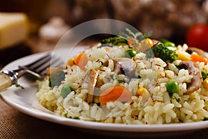 Classic Risotto with mushrooms and vegetables served on a white plate