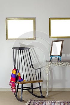 Classic rocking chair and wooden ornate brown desktop photo frame on old style vintage table