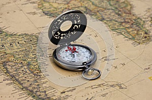 Classic round compass on background of old vintage map of world