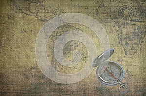 Classic round compass on background of old vintage map of world