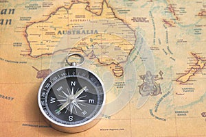 Classic round compass on background of old vintage map of world