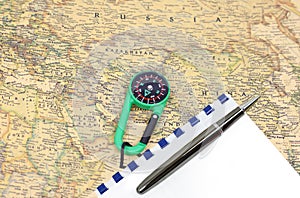 Classic round compass on background of old vintage map of world