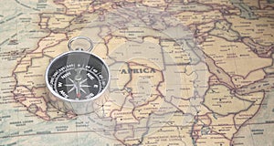 Classic round compass on background of old vintage map of world as symbol of tourism with compass