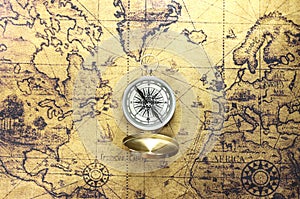 Classic round compass on background of old vintage map of world as symbol of tourism with compass, travel with compass and outdoor