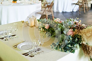 Classic serving in the restaurant, plates of glasses, and forks.Making a pampas grass and greenery. Floristics.