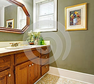 Classic simple green bathroom with wood cabinets.