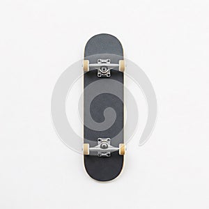 A classic skateboard with black griptape and light wheels