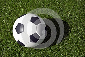 Classic soccer ball on a grass field. View from above on retro classic football ball