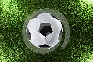 Classic soccer ball on the grass illuminated by four spotlights