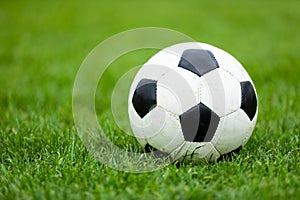 Classic Soccer Football Ball on Soccer Pitch. Green Grass Soccer Field