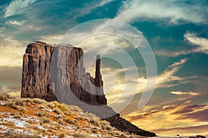 Classic southwest desert landscape under an evening sky and bright sun in Monument Valley