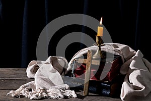 Classic Still Life with an Old Book, Holy Bible, Crucifix, and Lit Candle on a Wooden Table