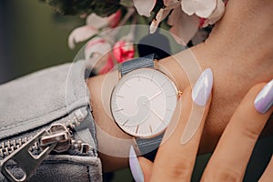 Classic stylish white watch on woman hand. Close-up photo