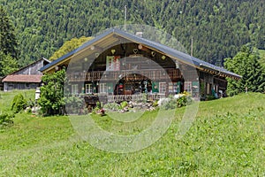 Classic swiss chalet in the middle of green alpine meadows . Cozy rural village Champery in Switzerland. The slopes of the