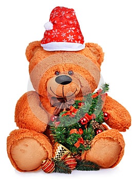 Classic teddy bear in red hat with christmas tree