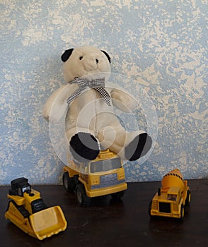 Classic Teddy Bears against a Blue Wall And Classic Construction Vehicles