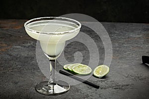 Classic tequila Margarita cocktail in a glass decorated with salt and lime