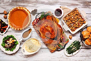 Classic Thanksgiving turkey dinner. Overhead view table scene on a rustic white wood background.