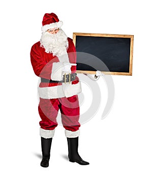 Classic traditional red santa claus holding empty wooden slate blackboard chalkboark pointing with finger on it. blank slate with