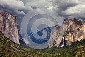 Classic view of scenic Yosemite Valley with famous El Capitan and Half Dome rock climbing summits and Bridal Vei waterfall, with a